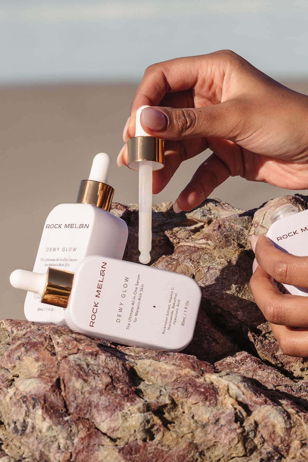 serum specifically formulated for skin of colour, two bottles on rocks